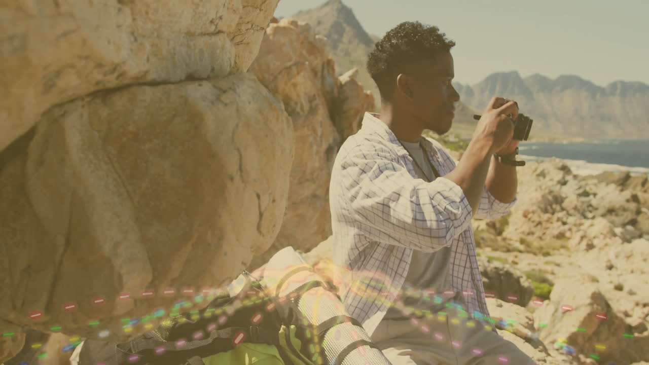 Taking photos, man with camera capturing colorful light trails in rocky landscape