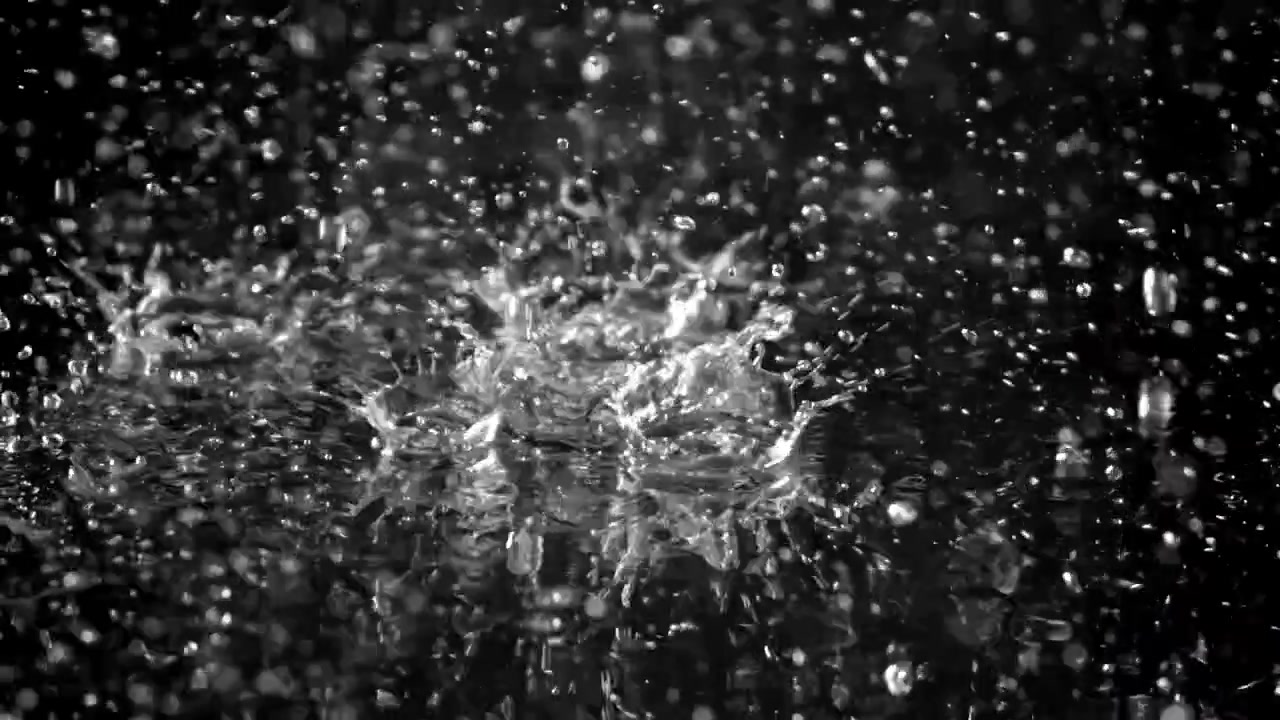 Slow Motion Water Droplets Splashing on a Dark Surface