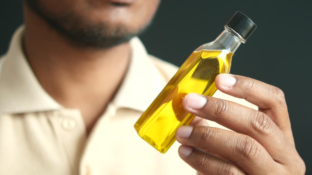 올리브 오일 한 병 을 들고 있는 남자