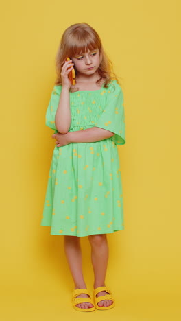 tired sleepy child girl kid talking on smartphone with friend or mother annoyed boring online talk