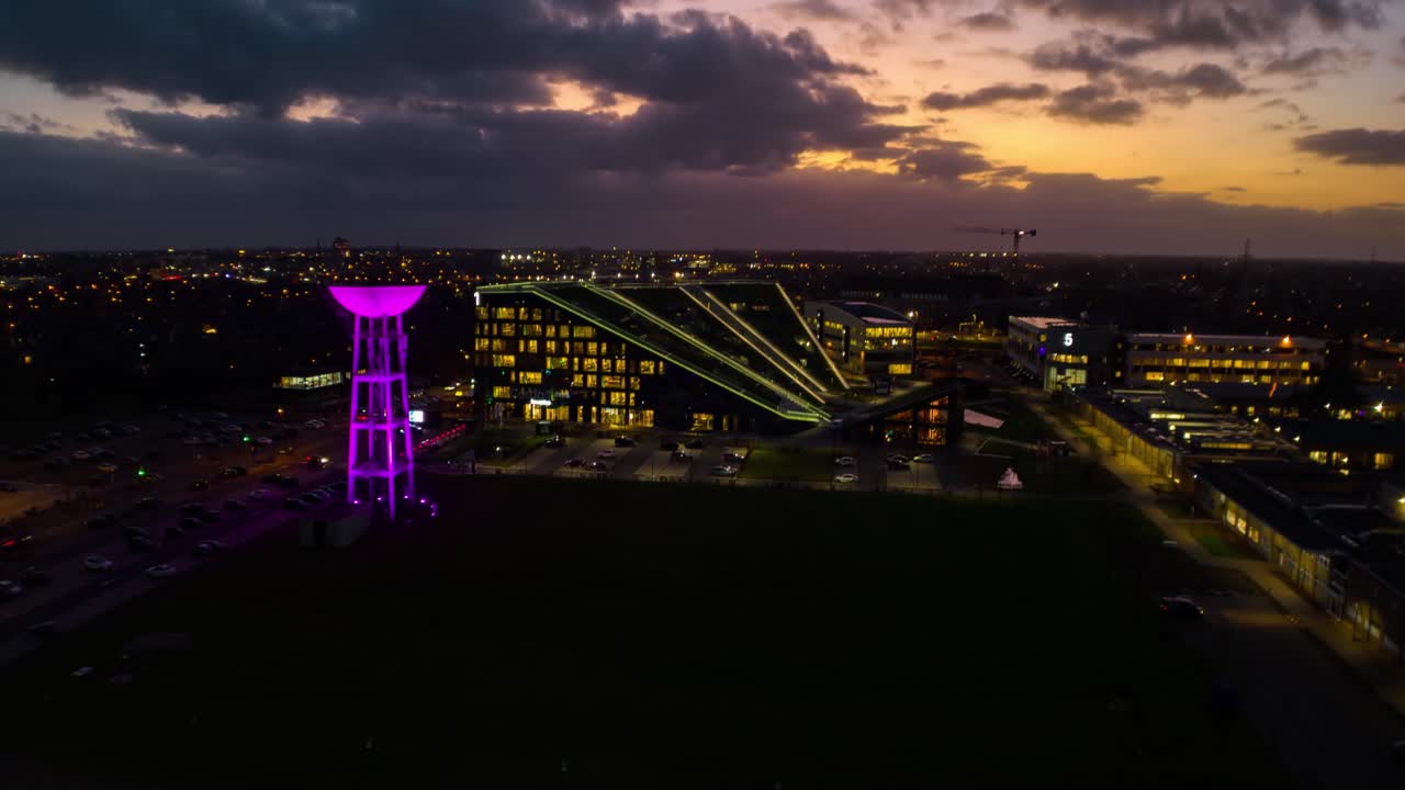 hiperlapso de edificio de oficinas moderno con torre de agua brillante en la noche, antena