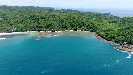 Perfect-beach-and-rain-forest-on-tropical-coast-of-Wediombo-lagoon,-Indonesia