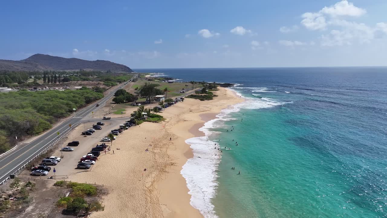 Aerial drone footage over Hawaii’s lush green mountains and tropical coastline, showcasing turquoise ocean waters, palm trees, scenic valleys, and vibrant island landscapes from above