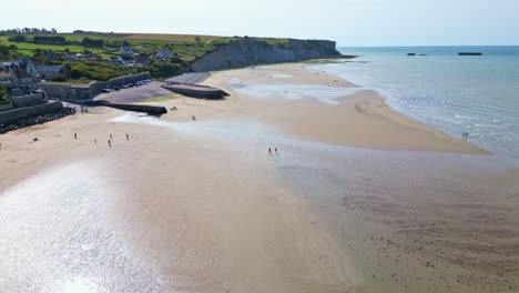 upward aerial movement above the settlement on arromanches-les-bains shoreline, france