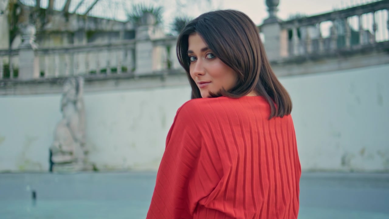 Turista che esplora la terrazza del centro storico. Ragazza che si gira e guarda la fotocamera all'aperto.