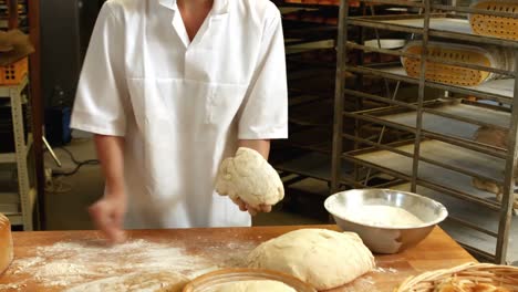 female baker kneading a dough