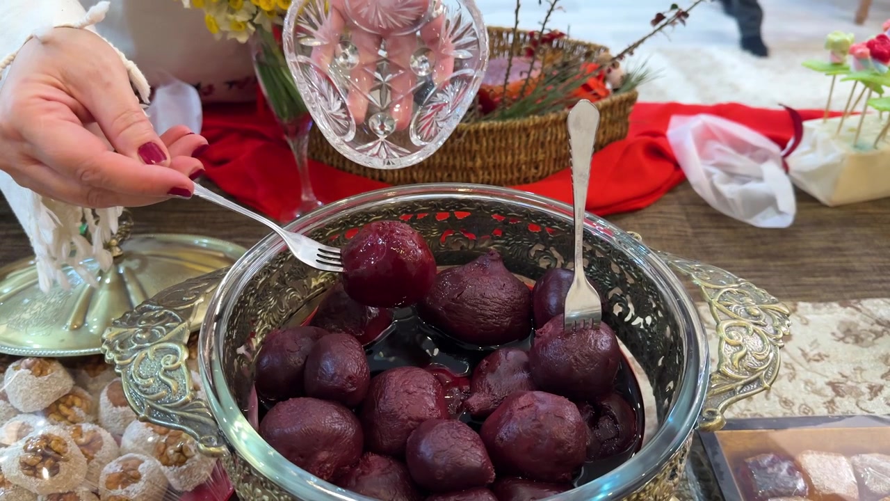 Persian Yalda event ceremony of red pomegranates arranged table in crystal serving dish beetroot cooked glossy fork lifting celebration culture ruby warm symbolizing in Tehran Iran winter gathering