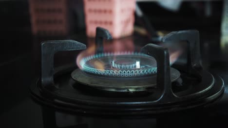 video of a black gas stove with blue and red burning flame in the kitchen