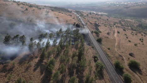 highway with burning passenger bus and stopped vehicle traffic, drone flyover