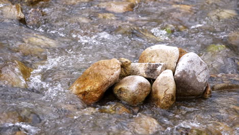 corriente clara que corre a través de rocas de piedra río abundante que fluye en cámara lenta