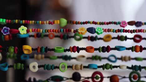 homemade bead necklace bracelets hanging at street vendor market, vertical