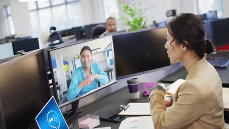 mujer de negocios asiática en la oficina usando computadora con videollamadas y mensajería ai en pantallas