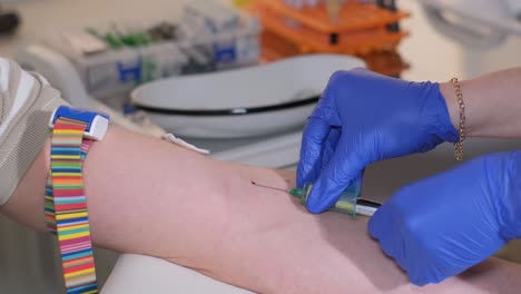 a female doctor takes a blood test from a patient’s arm. the concept of treating people in a clinic.