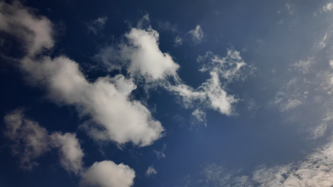 Bright blue sky with fluffy white clouds on a sunny and clear day, natural background, inspiring peace of mind