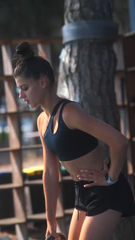 young woman exercising with kettlebell outdoors