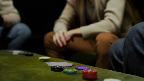 side view of the hands of a woman who take playing cards and poker chips on the table 1