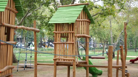 patio de recreo de madera con techo verde y tobogán