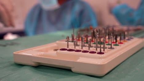 conjunto de tornillos con dentistas trabajando detrás. efecto bokeh