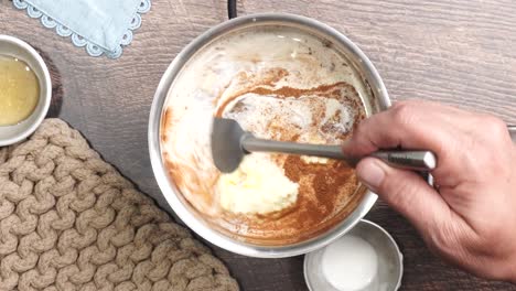 baking delicious caramel pecan brownies. in a sauce pan adding butter and cream to the other ingredients. freshly baked gooey chocolate brownies with sweet caramel and nutty pecans.