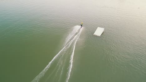 Drone-shot-of-a-person-wake-boarding-on-the-lake-Zlate-Piesky,-Bratislava,-Slovakia