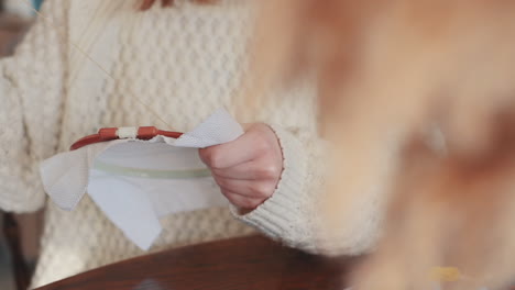 the hands of an unrecognizable female cross stitching