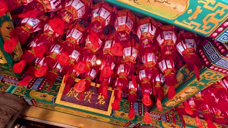 red lanterns adorn a traditional temple ceiling