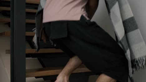 cropped view of freelance worker use laptop, sitting on wooden stairs at home in plaid