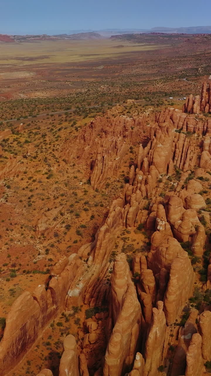 Deserted landscape with amazingly-shaped rocks from air erosion. Arches National Park canyons from aerial view. Vertical video