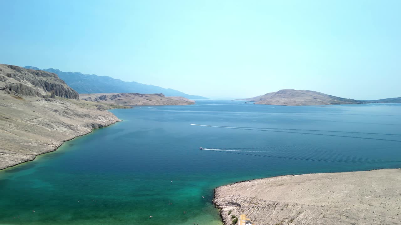 An aerial footage over beautiful beach, green and blue waters of Adriatic, stunning barren landscape on island Pag, Croatia in summer