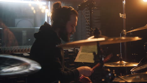 male musician in headphones plays the drums