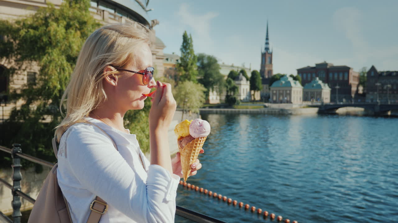 스톡홀름 시의 눈에 띄는 전망을 배경으로 아이스크림을 먹는 여성 관광객