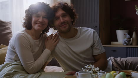 couple enjoying easter breakfast in bed