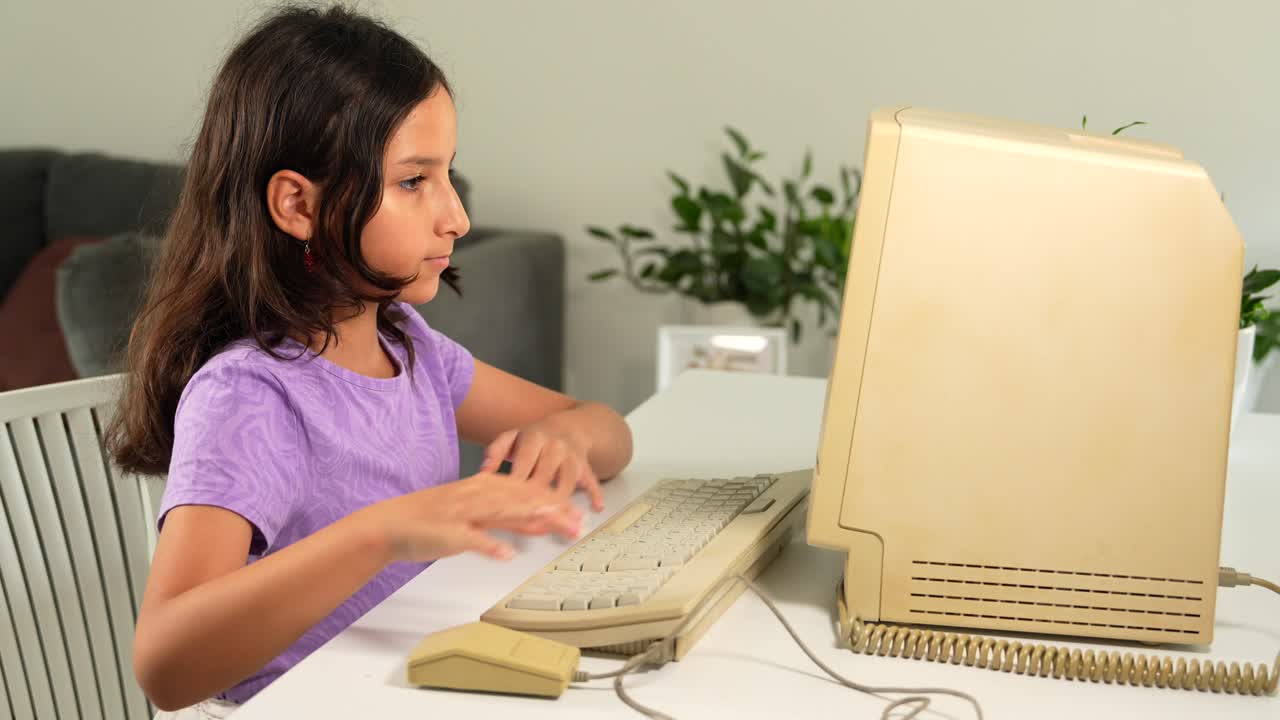 niña hispana escribiendo un teclado de computadora vintage y moviendo el ratón