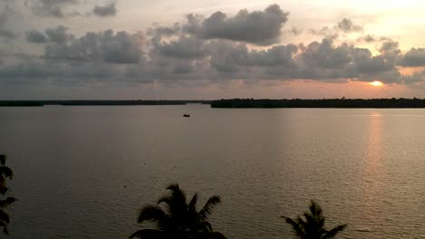 Wunderschöne-Luftaufnahme-Eines-Backwater-Vembanadu-Sees,-Wasserlinien,-Sonnenuntergang-In-Der-Dämmerung,-Kokosnussbäume,-Wassertransport,-Wolken,-Reflation,-Hausboot,-Rote-Sonne