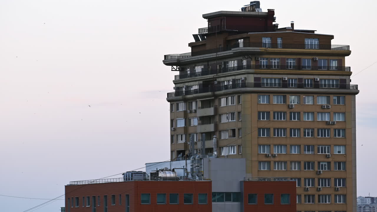 Time lapse of a tall building with balconies and windows at sunset