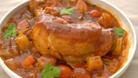 estofado de pollo casero con tomates, cebollas, zanahorias y patatas en el plato