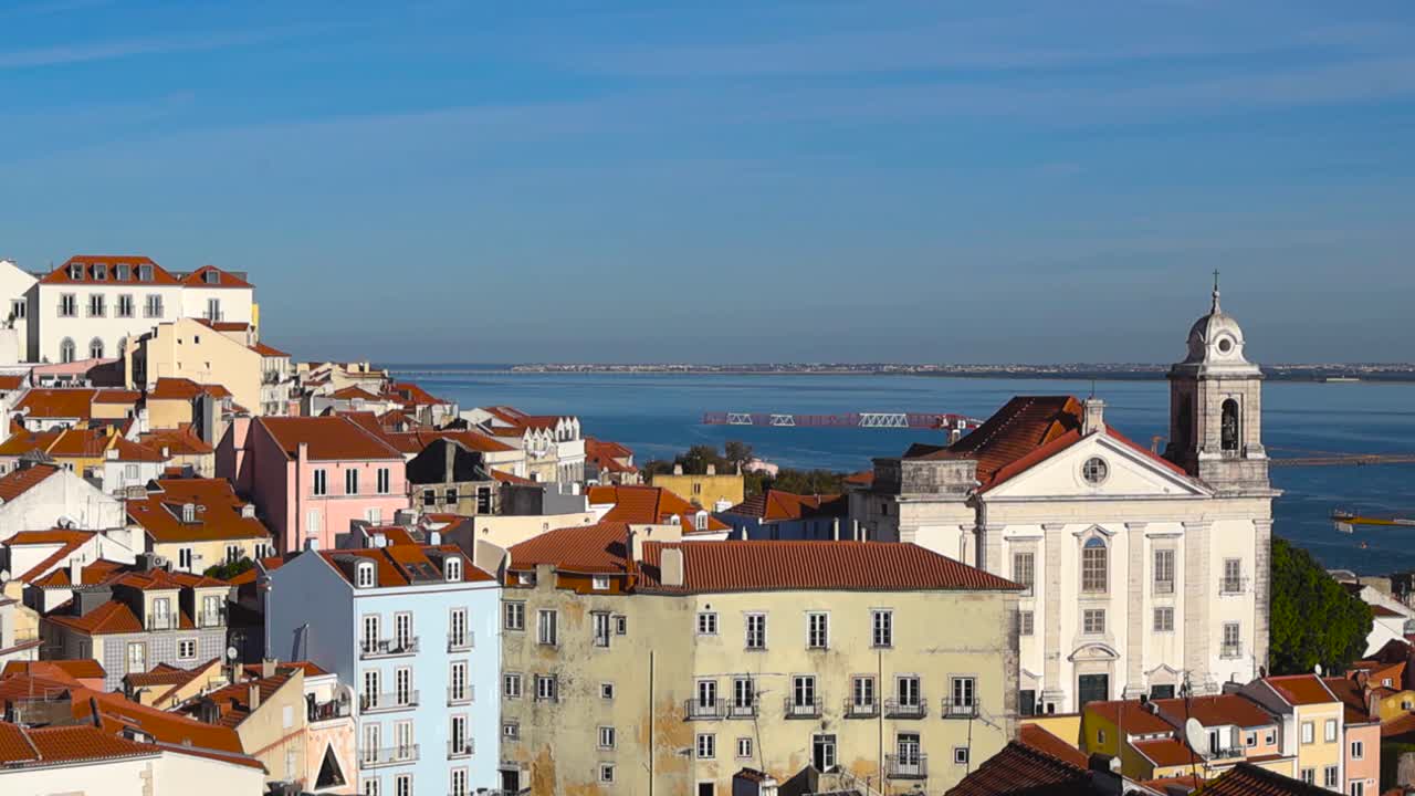 Vista panorámica desde Portas do Sol sobre los coloridos tejados rojos tradicionales de Alfama, las iglesias y la ribera, la arquitectura histórica de Lisboa y el emblemático horizonte del Panteón Nacional hacia el río Tajo