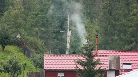 chimney smokes from the roof of a cottage in the countryside