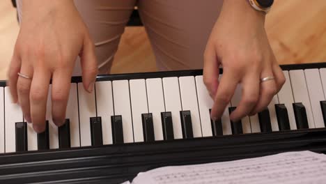 female playing piano, top down view, camera moves to black, in camera transition fade