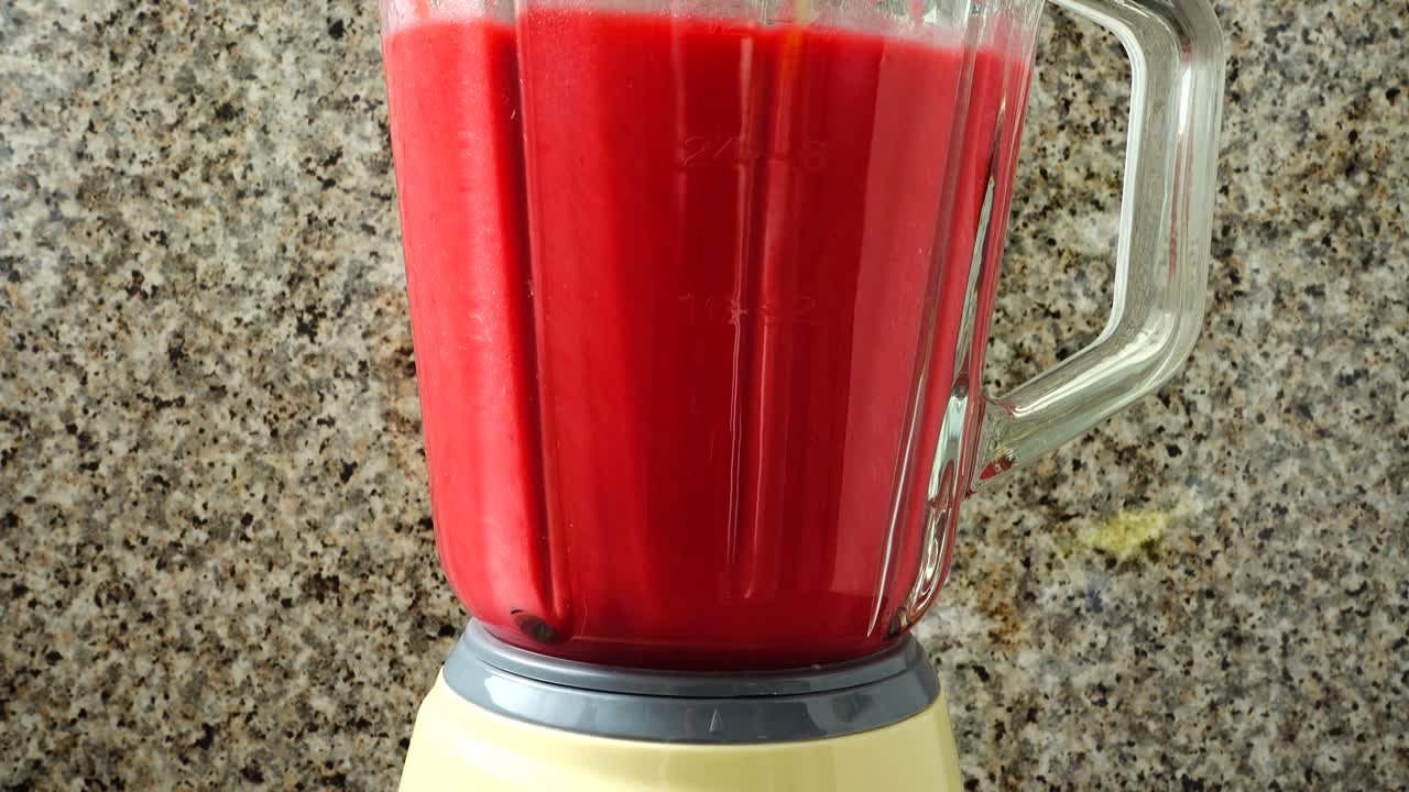 Preparazione di un cocktail di lamponi, banane e mele nel frullatore. Processo di preparazione del cocktail.