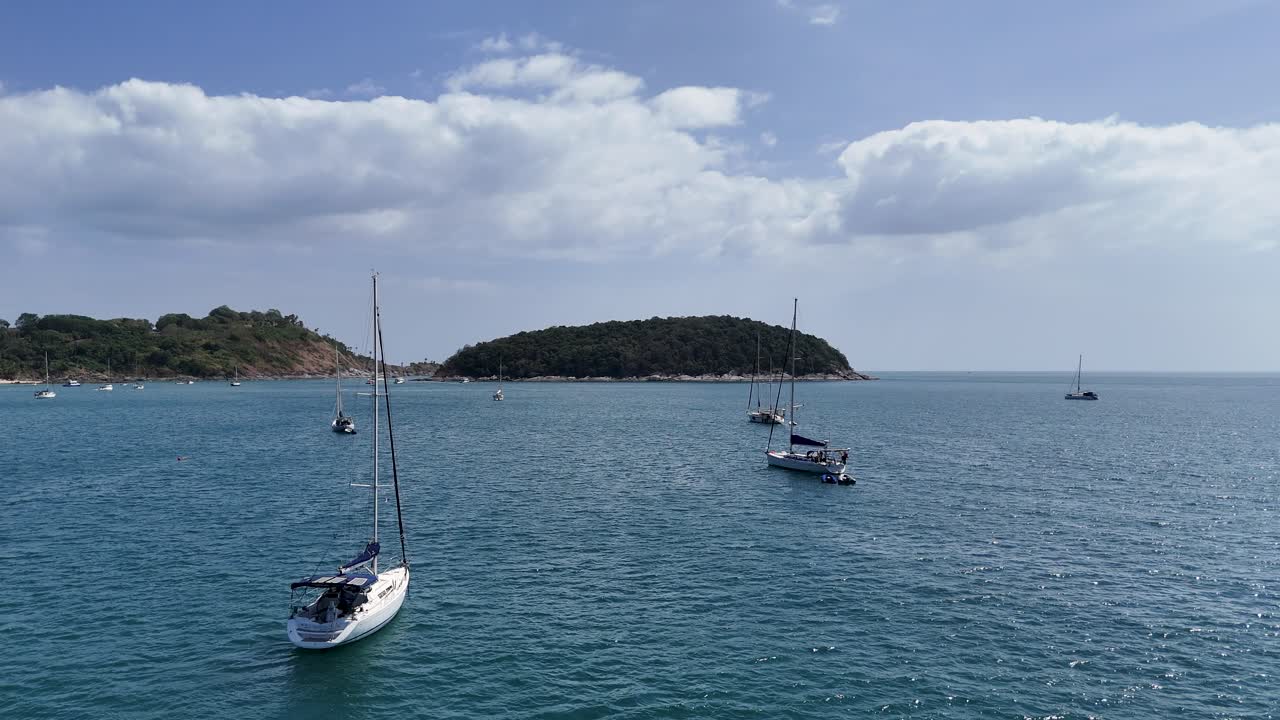 imágenes de drones capturan veleros en una serena bahía de phuket, mostrando aguas tranquilas y islas exuberantes bajo cielos despejados
