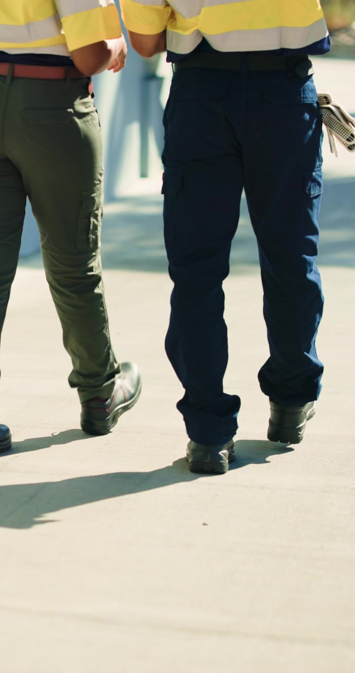 Two Construction Workers Walking Together on Site