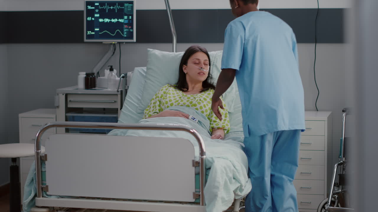 asistente afroamericano arregla la cama de la mujer enferma durante la recuperación de la enfermedad