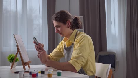young artist using smartphone for reference