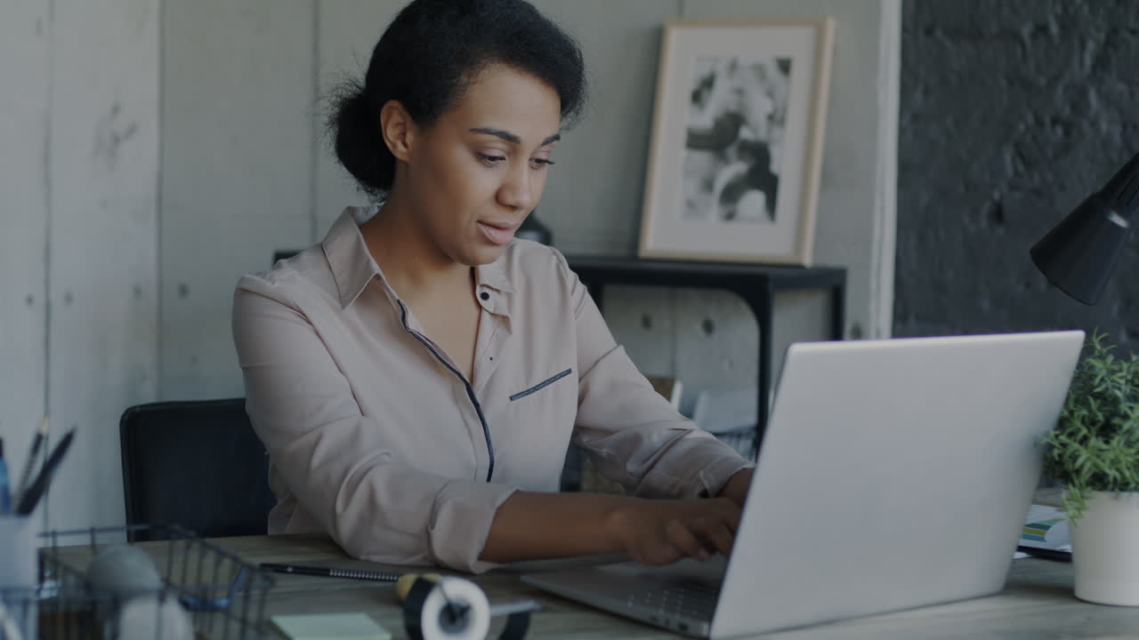 African American Woman Working on Laptop in Modern Office