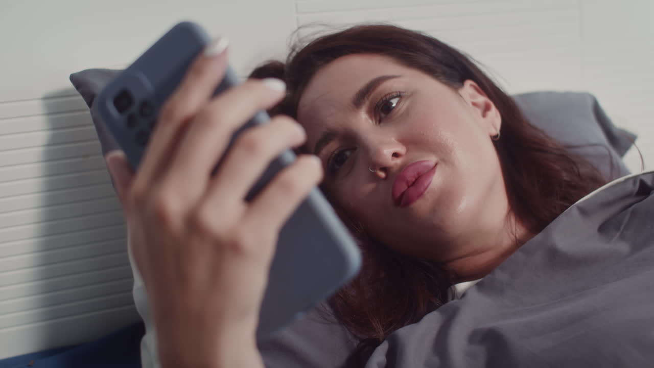 mujer joven usando teléfono inteligente en la cama