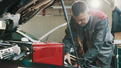 car mechanic working on a car engine