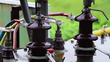 electric power transformer during rain close-up footage. wet insulators and cables show real-time outdoor power infrastructure under harsh weather conditions. ideal for industrial visuals