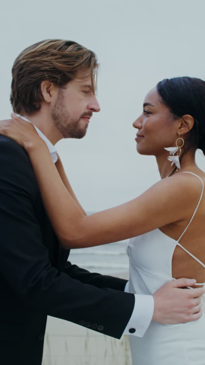 해변에서 키스하는 결혼 부부