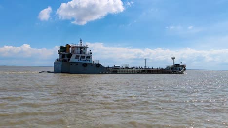 A-fully-loaded-cargo-ship-sails-over-the-Padma-river,-showcasing-water-transportation-in-action